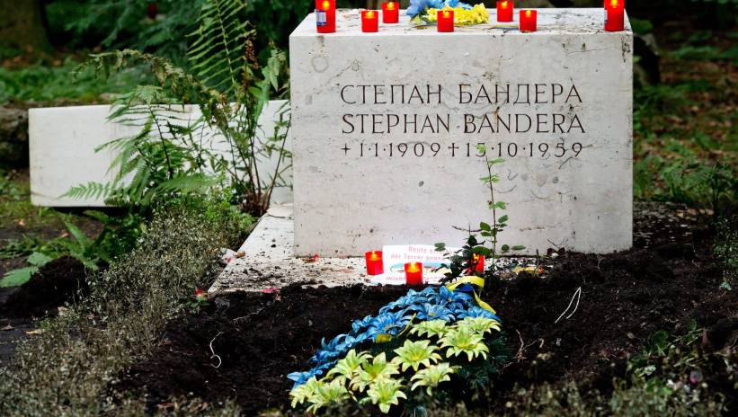Fot. PAP/EPA/SVEN HOPPE epa04358397 Candles stand lit on the gravestone as flowers in the Ukrainian national colours blue and yellow grow on the defiled grave of late controversial Ukrainian Stepan Bandera on a cemetery n Munich, Germany, 17 August 2014. During World War II, Bandera (1909-1959) took an ambivalent position towards Nazi Germany as he first welcomed Nazi troops to Ukraine and was later arrested for preparations of a revolt against Nazi troops. The grave serves as a monument for the Ukrainian diaspora in Munich. EPA/SVEN HOPPE Dostawca: PAP/EPA.