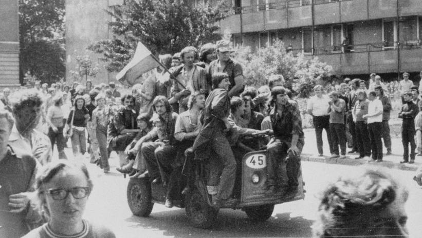 Fot. PAP/reprodukcja Radom, 1976-06-25. Wydarzenia radomskie, radomski czerwiec. Nz. grupa młodych ludzi jadących akumulatorowym wózkiem z narodową flagą pod gmach Komitetu Wojewódzkiego Polskiej Zjednoczonej Partii Robotniczej (KW PZPR). łp/gr PAP Radom, June 26, 1976. Strikes in Radom. The Radom June. Pictured: a group of young people on their way to the Voivoidship Committee of the Polish United Workers Party. hey drive the electric cart amd hold the national flag to the . łp/gr PAP